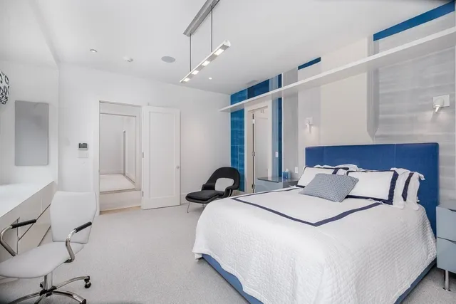 a spacious bedroom with a bed and a large mirror