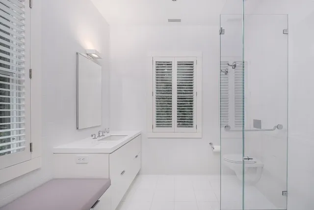 a bathroom with a double vanity sink a mirror and a bathtub