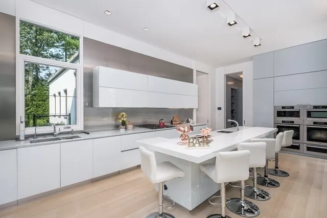 a kitchen with a dining table chairs and white cabinets