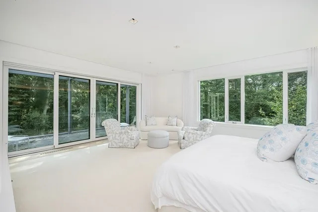 a bedroom with furniture and large windows