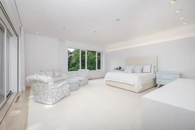 a spacious bedroom with a bed and a large window