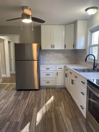 a kitchen with a refrigerator a sink and cabinets