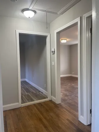 an empty room with wooden floor and closet area