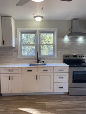 a kitchen with stainless steel appliances granite countertop a stove a sink and a microwave