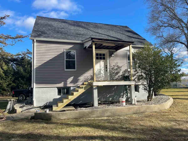 a view of a house with a yard and sitting area