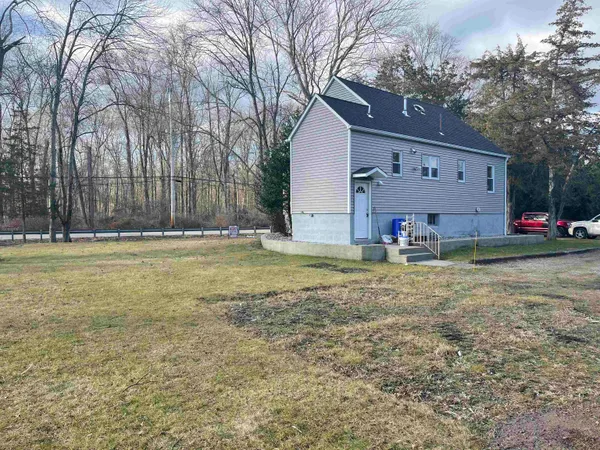 a view of a house with backyard and tree