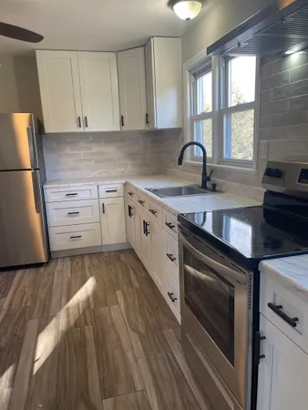 a kitchen with granite countertop white cabinets and white appliances