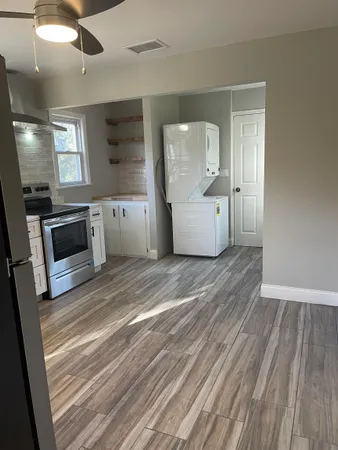 a view of a kitchen with wooden floor and electronic appliances