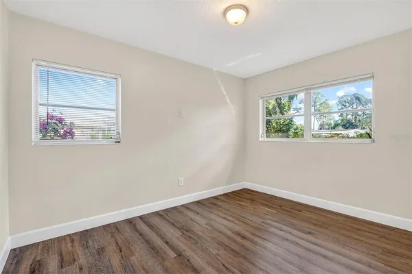 a view of a room that has wooden floor and window
