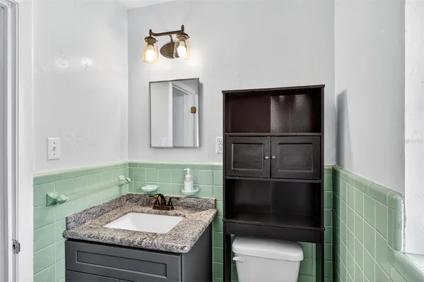 a bathroom with a granite countertop sink and a mirror