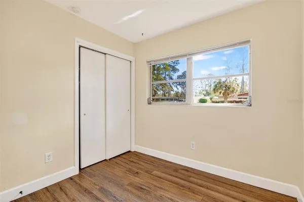 an empty room with wooden floor and window