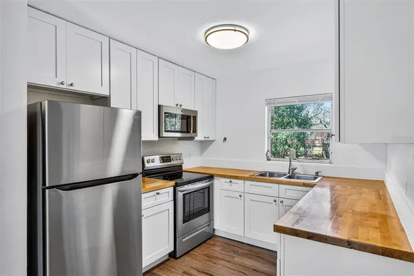 a kitchen with white cabinets and stainless steel appliances