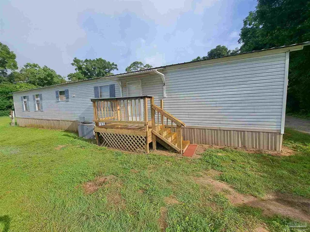 a view of a house with a yard and deck