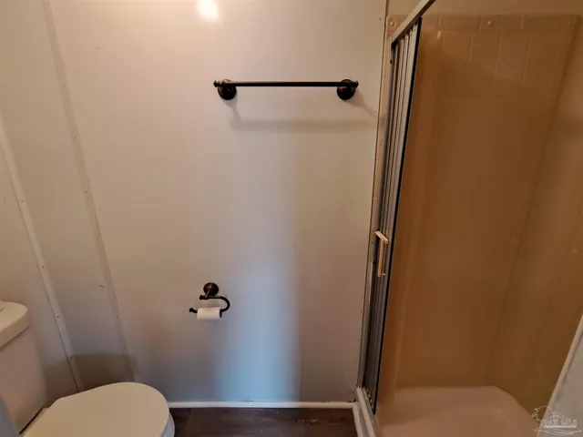 a bathroom with a granite countertop toilet and a shower