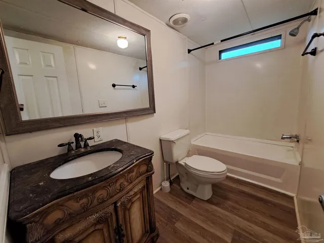 a bathroom with a sink a toilet a mirror and shower