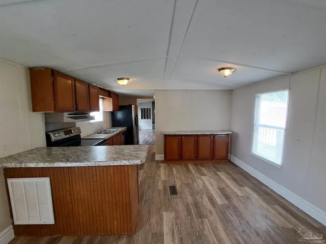 a kitchen with stainless steel appliances granite countertop a sink a stove counter space and cabinets