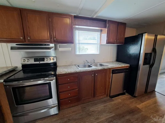 a kitchen with granite countertop wooden cabinets and stainless steel appliances