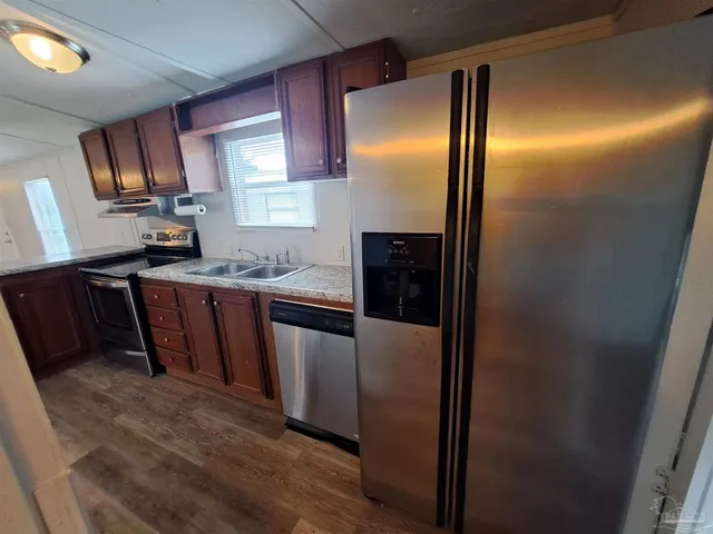 a kitchen with granite countertop stainless steel appliances a counter top space and cabinets