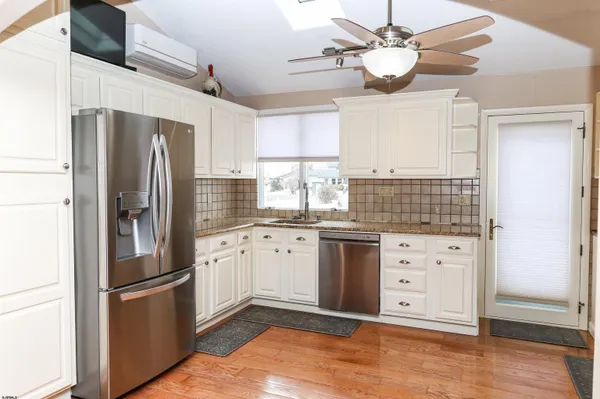 a kitchen with granite countertop white cabinets and stainless steel appliances