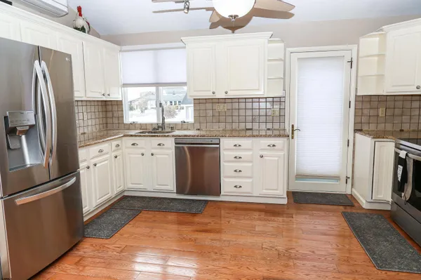 a kitchen with granite countertop a refrigerator and a sink