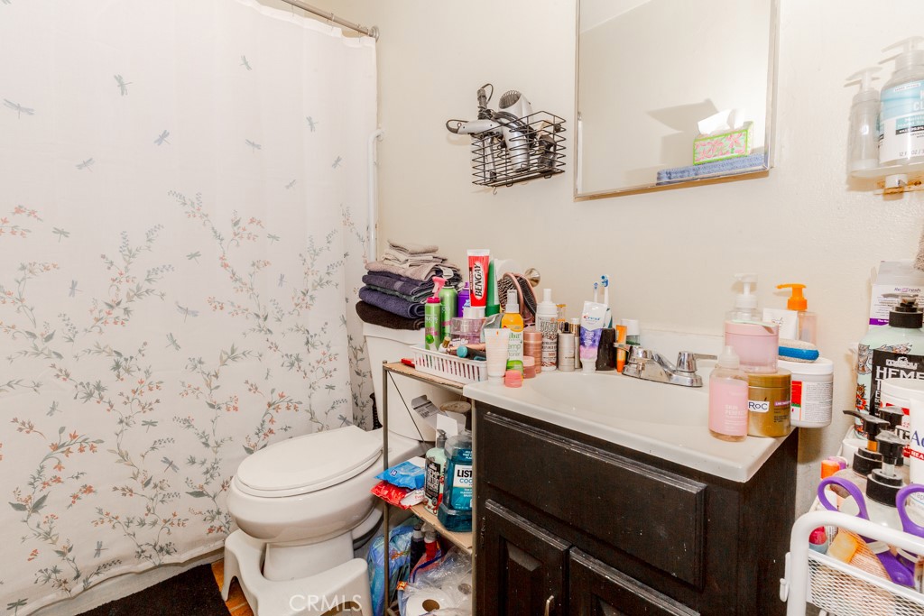 518 West Fredricks Street Barstow, CA 92311 - Photo 27 of 35 a bathroom with a sink a toilet and a shower curtain