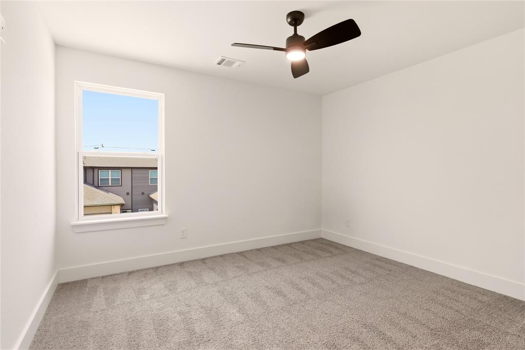 8909 Lowell Street Rowlett, TX 75089 - Photo 11 of 25 Empty room with light colored carpet and ceiling fan