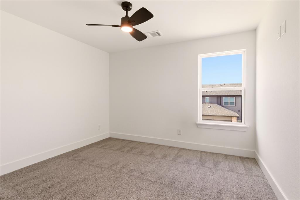 8909 Lowell Street Rowlett, TX 75089 - Photo 13 of 25 Spare room with light colored carpet and ceiling fan