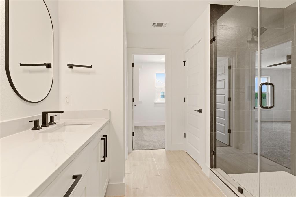 8909 Lowell Street Rowlett, TX 75089 - Photo 15 of 25 Full bathroom featuring vanity, a shower stall, and wood finish floors
