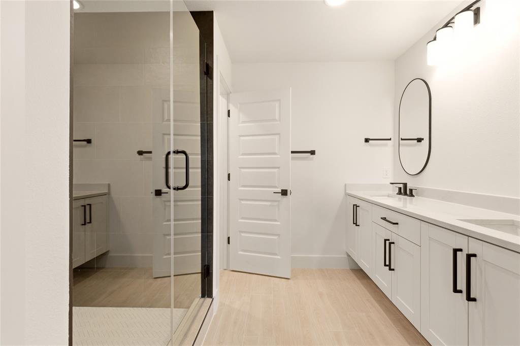 8909 Lowell Street Rowlett, TX 75089 - Photo 16 of 25 Full bath with double vanity, a stall shower, and light wood-style floors