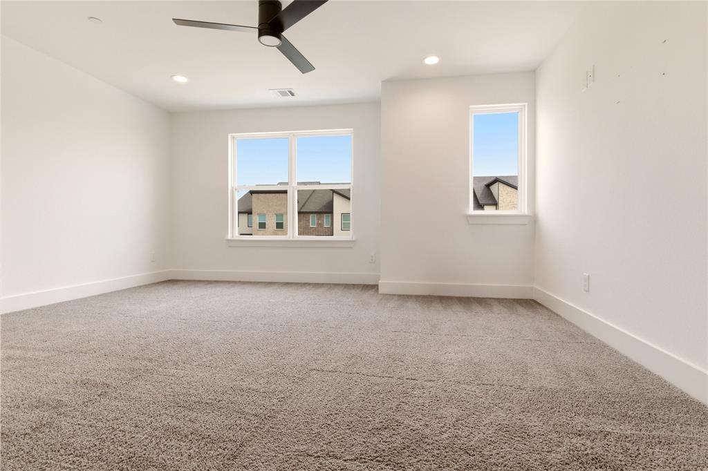 8909 Lowell Street Rowlett, TX 75089 - Photo 19 of 25 Empty room featuring light colored carpet, plenty of natural light, and ceiling fan