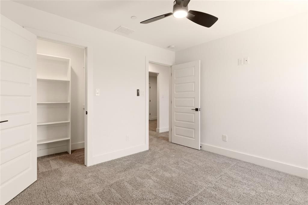 8909 Lowell Street Rowlett, TX 75089 - Photo 9 of 25 Unfurnished bedroom with a spacious closet, light carpet, and a ceiling fan
