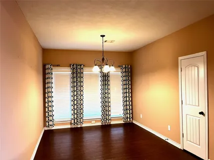 a view of a room with wooden floor closet and a window
