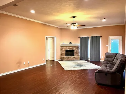 a view of empty room with wooden floor and fireplace