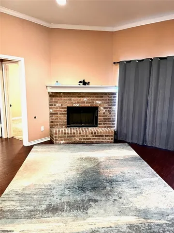 a view of empty room with wooden floor and fireplace