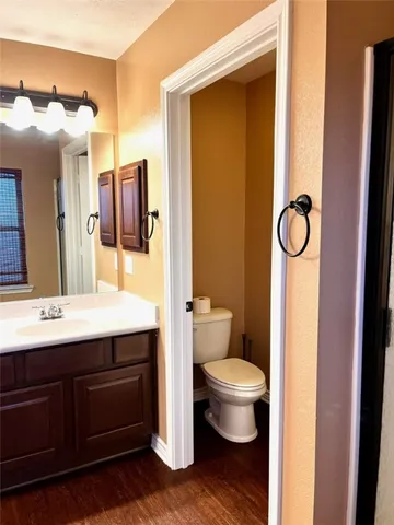 a bathroom with a granite countertop sink toilet and mirror