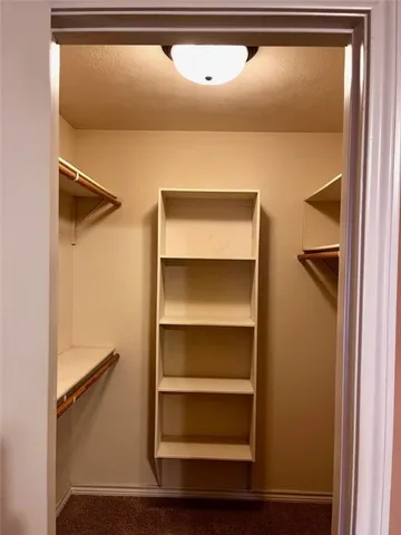 a view of walk in closet with empty racks