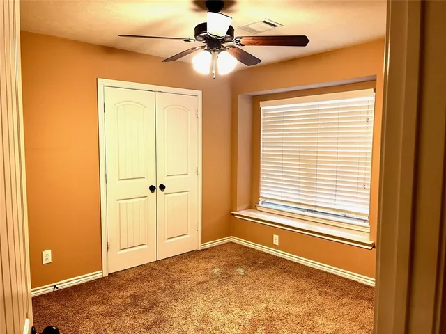 a view of a livingroom with a ceiling fan and window