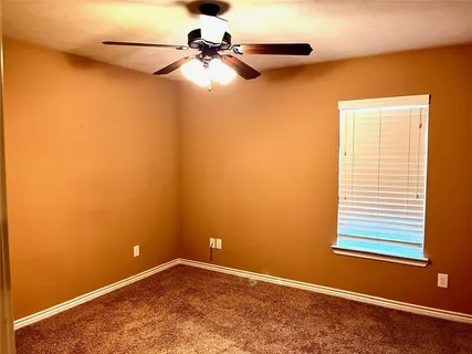 a view of a livingroom with a stove and a ceiling fan