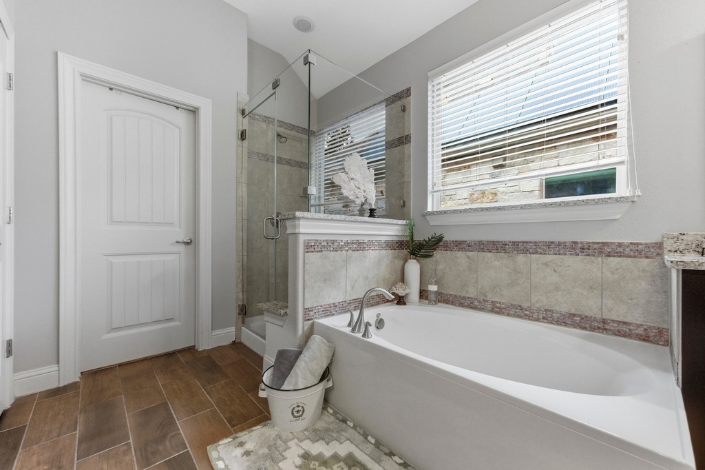 5425 Cherokee Draw Road Austin, TX 78738 - Photo 23 of 40 Indulge in a tranquil primary bath featuring a soaking tub and glass-enclosed shower.