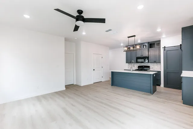 a kitchen with stainless steel appliances kitchen island granite countertop a refrigerator and a stove top oven