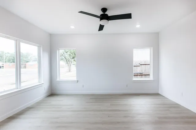 an empty room with a window and a ceiling fan