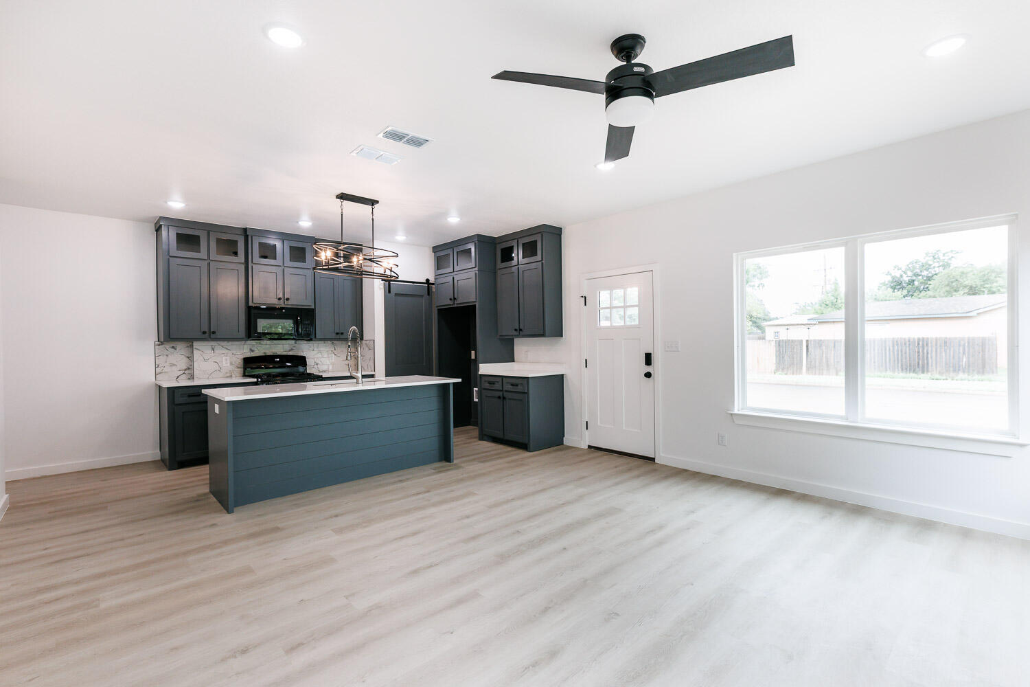 1704 Elkhart Avenue, Unit A Lubbock, TX 79416 - Photo 18 of 44 a kitchen with stainless steel appliances kitchen island granite countertop a sink cabinets and wooden floor