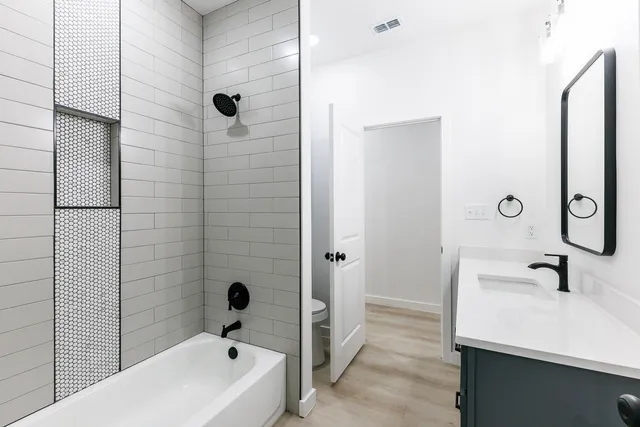 a bathroom with a tub sink and mirror