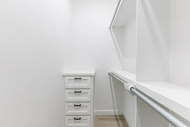 a view of walk in closet with empty racks