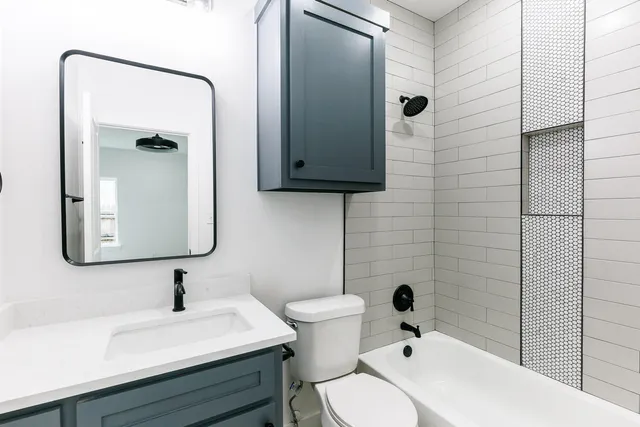 a bathroom with a sink a toilet and mirror