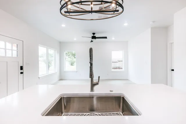 a view of a kitchen with a sink and chandelier
