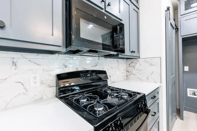 a kitchen with granite countertop a stove and a microwave