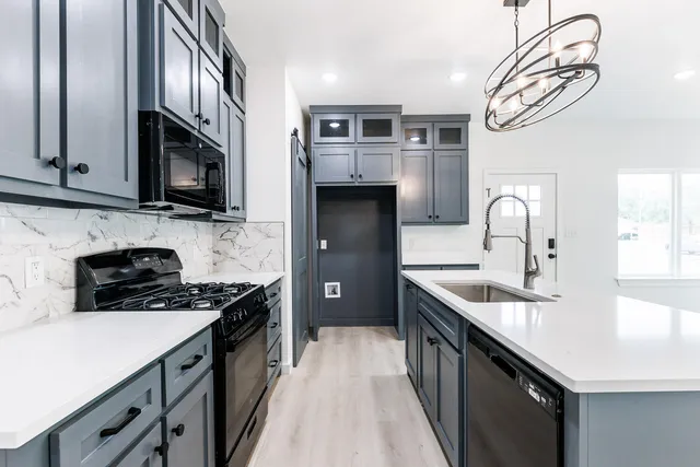 a kitchen with stainless steel appliances granite countertop a sink stove and refrigerator