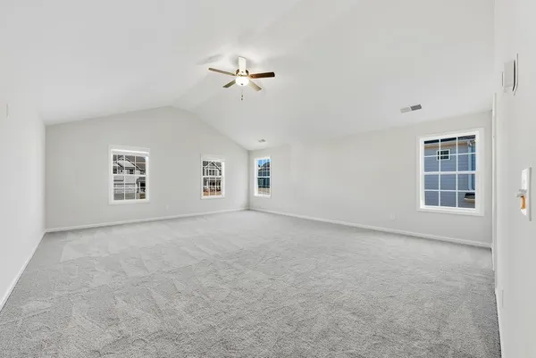 an empty room with windows and fan