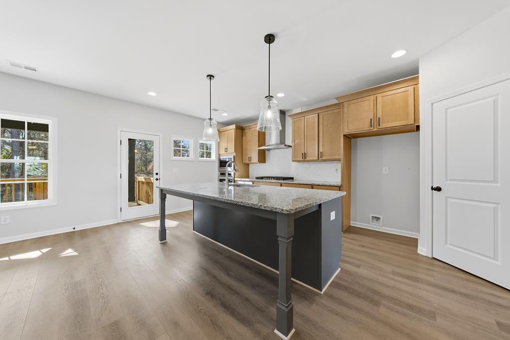 1304 McAlpine Ridge Auburn, AL 36830 - Photo 5 of 34 a kitchen with stainless steel appliances granite countertop a sink a stove and a wooden floor